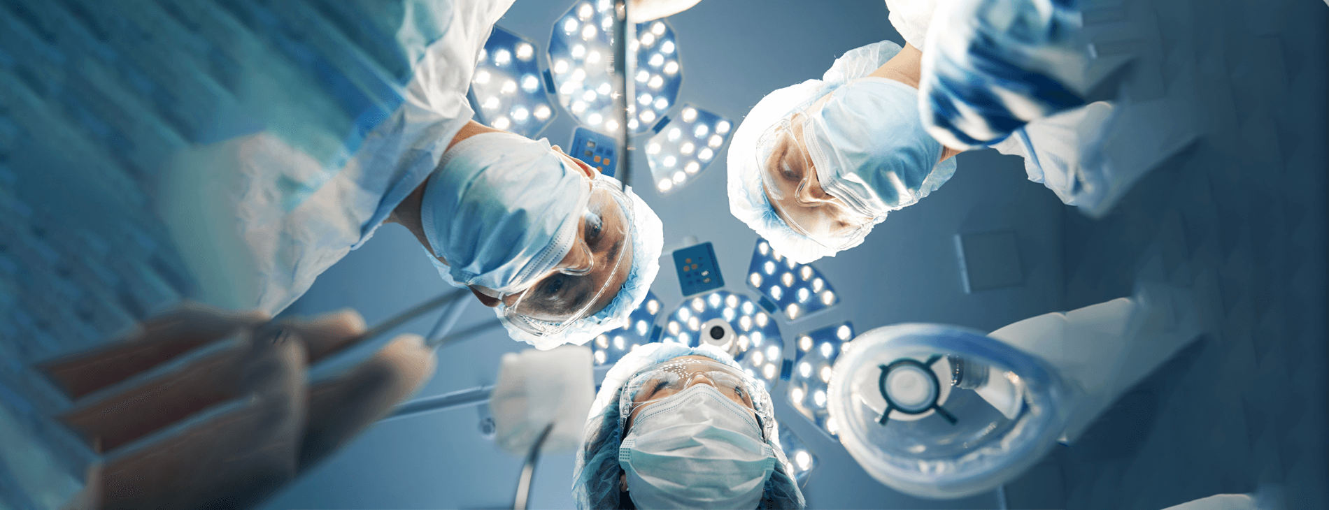 view of three medical professionals looking down on patient